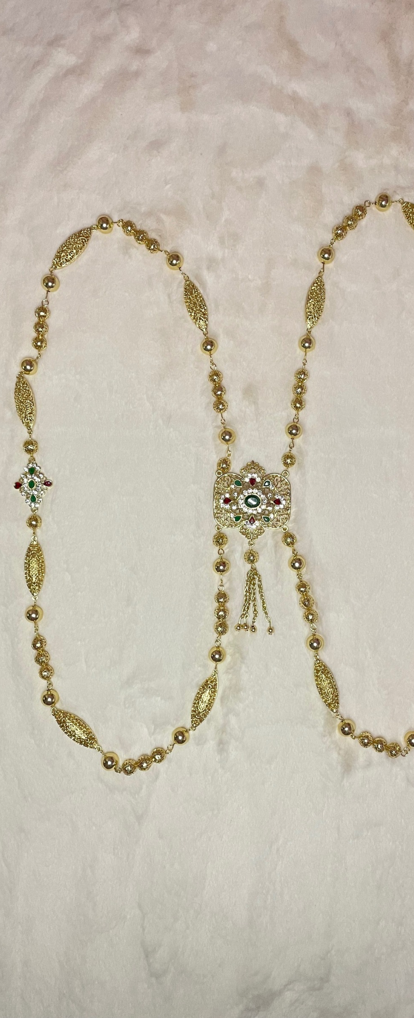 Bijoux de dos doré avec pendentif central et ornement coloré